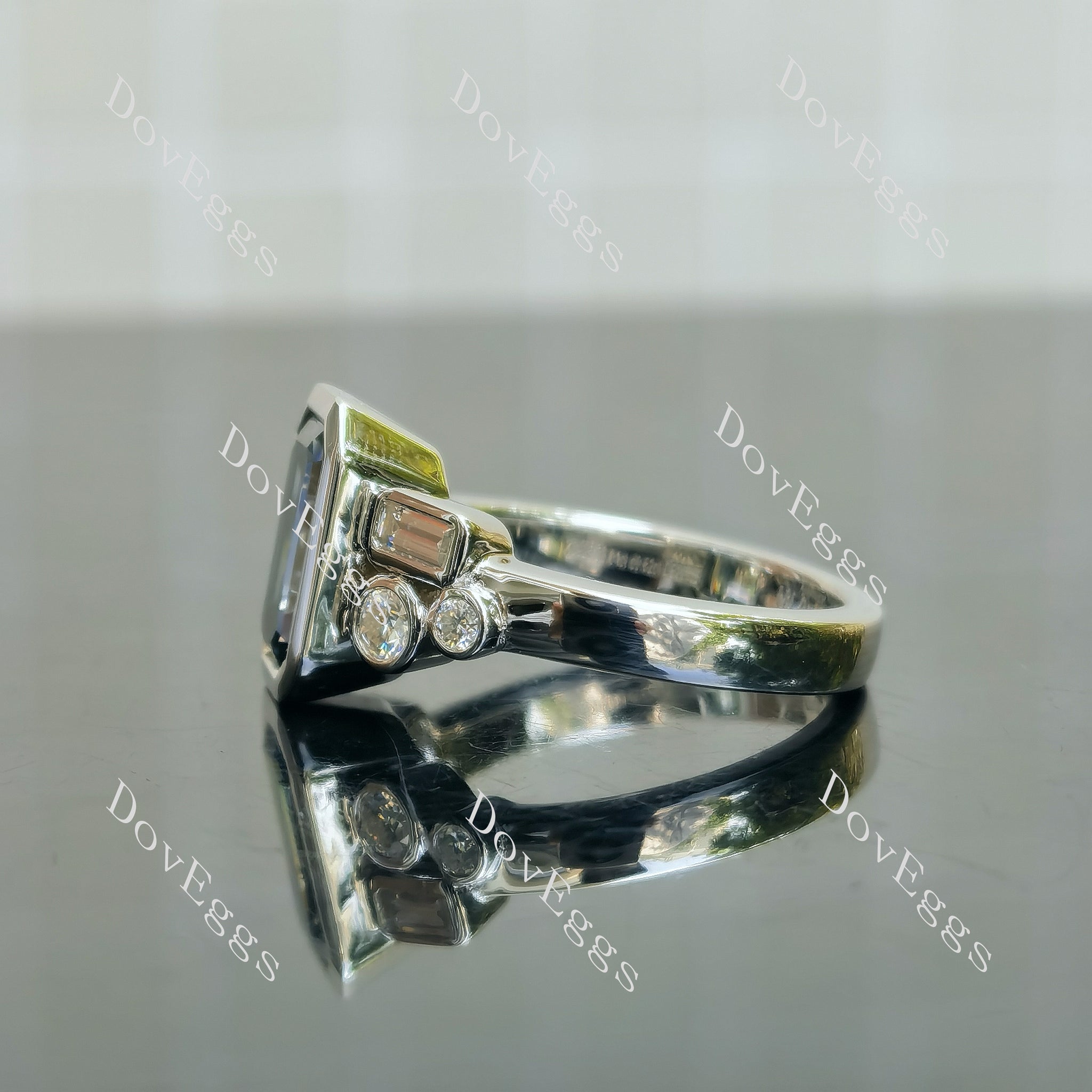 Doveggs elongated emerald bezel side stones twilight blue moissanite engagement ring