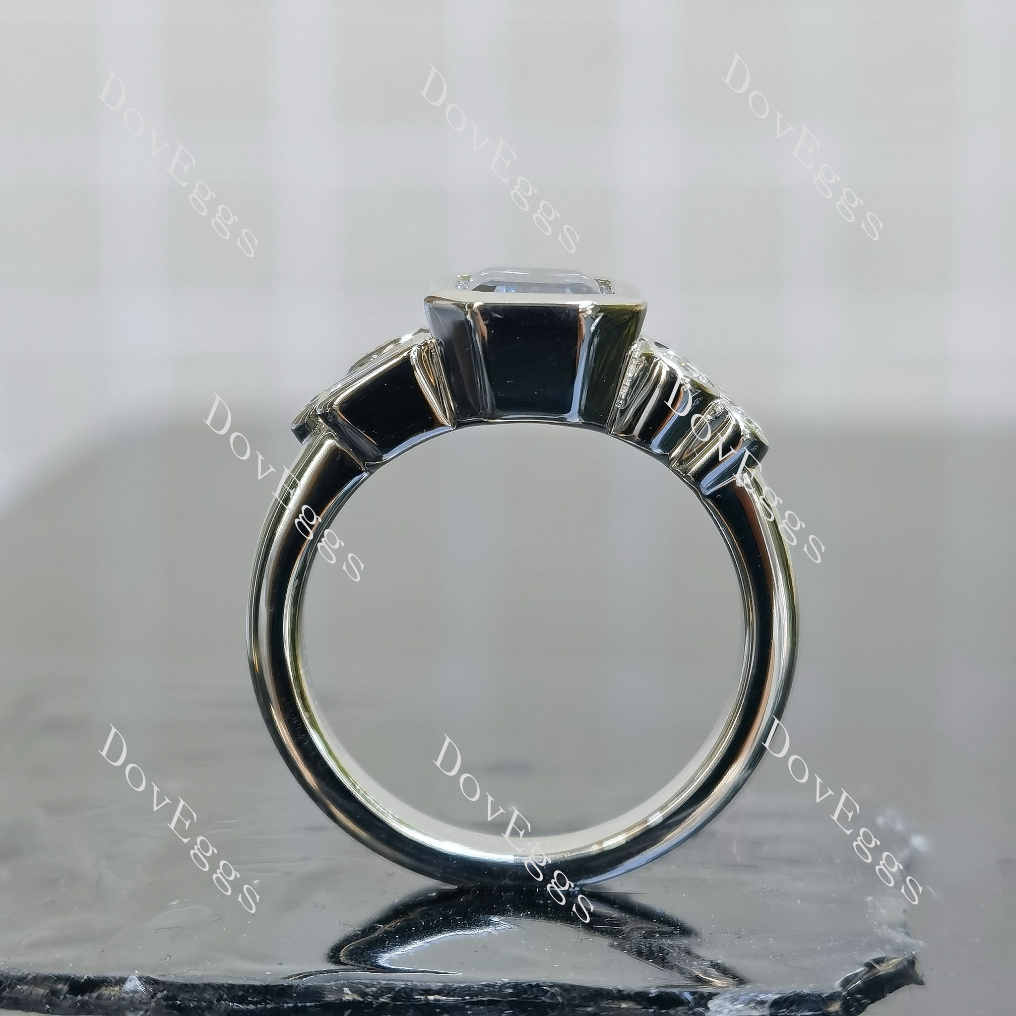 Doveggs elongated emerald bezel side stones twilight blue moissanite engagement ring