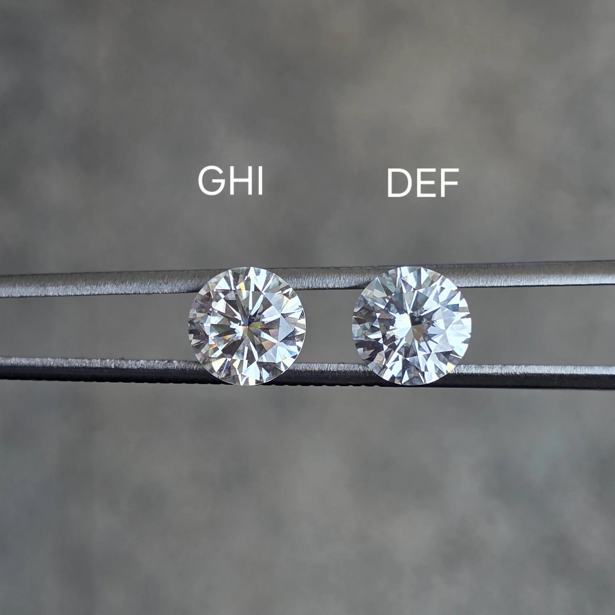Close-up photo of loose DEF and GHI moissanite stones in daylight, showcasing the subtle difference in tone and color grade.