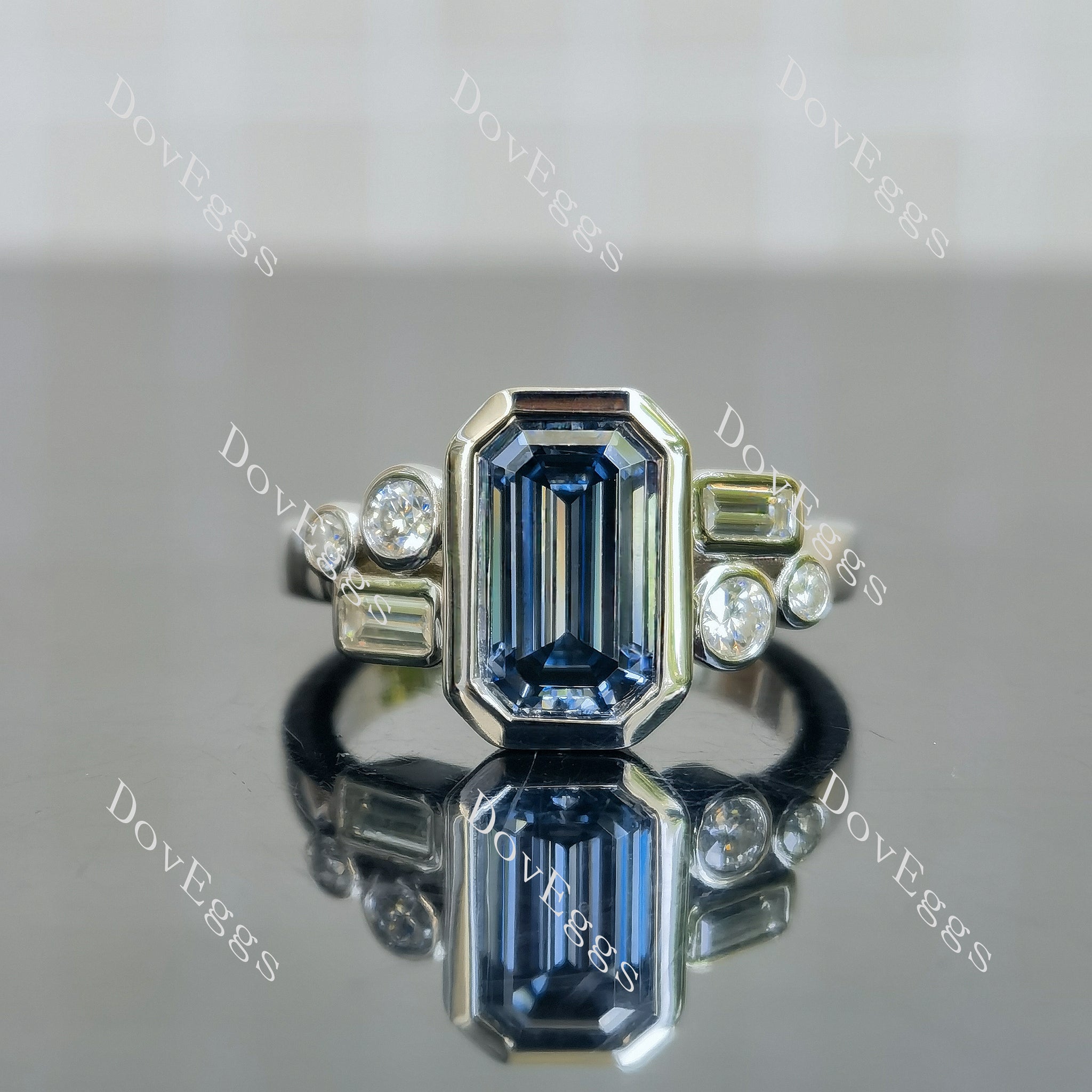 elongated emerald bezel side stones twilight blue moissanite
