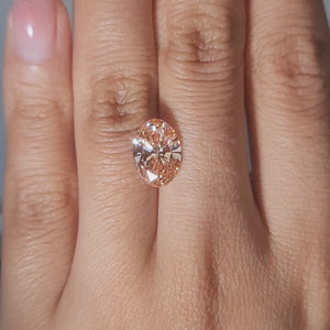 Handheld video of 3.07ct Oval pink diamond in warm lighting