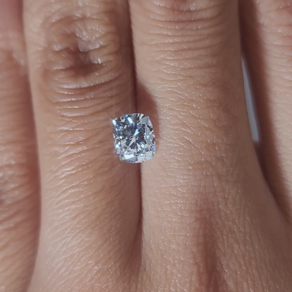 "Hand-modeled video of 1.03ct cushion diamond in warm indoor lighting"