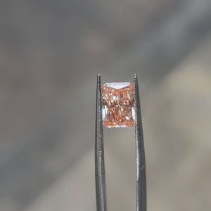 Natural daylight video highlighting 1.71ct radiant cut's vivid pink reflection