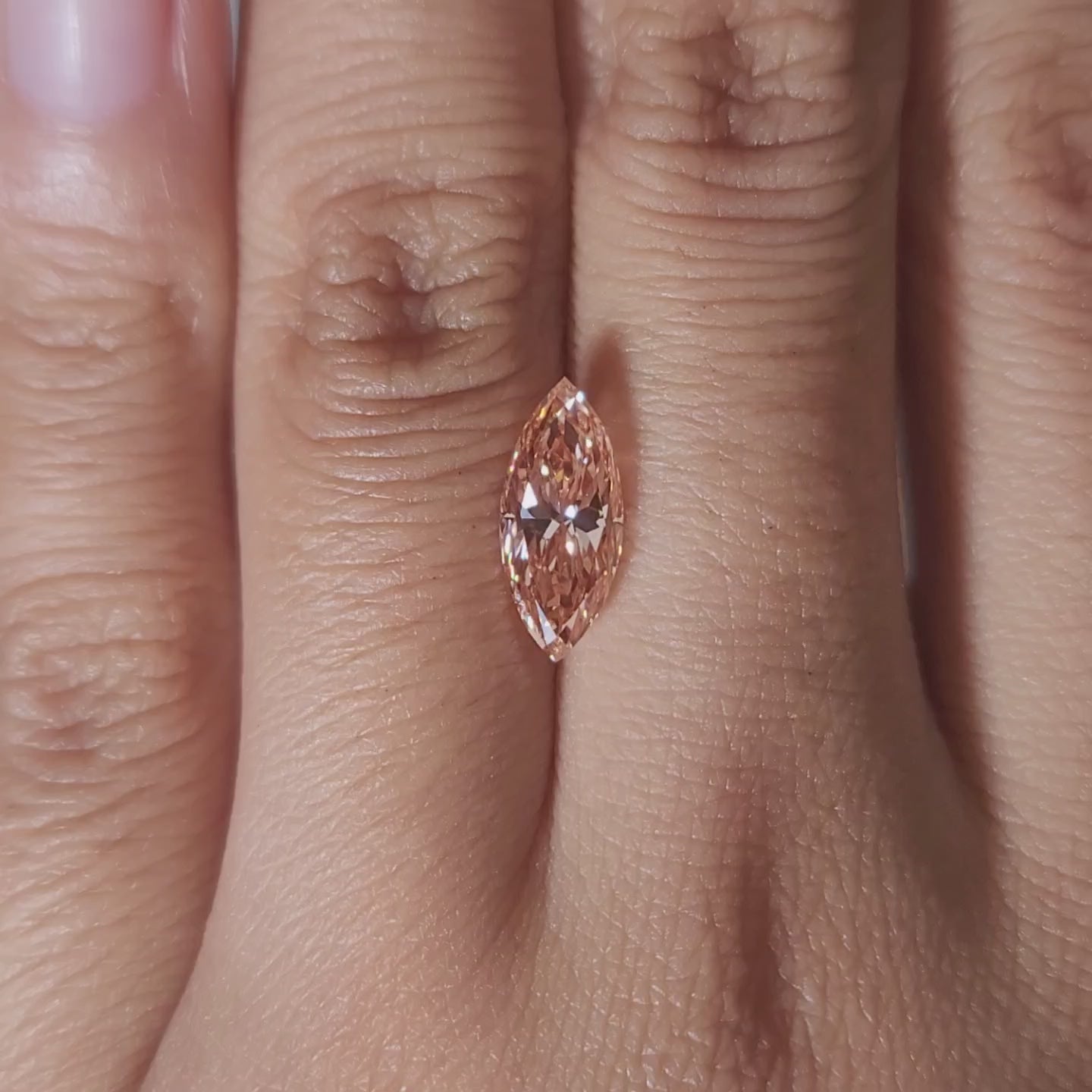 Close-up video of 2.03ct vivid pink marquise diamond under warm light