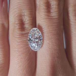 "Hand-modeled video of 3.007ct oval diamond in warm indoor lighting"