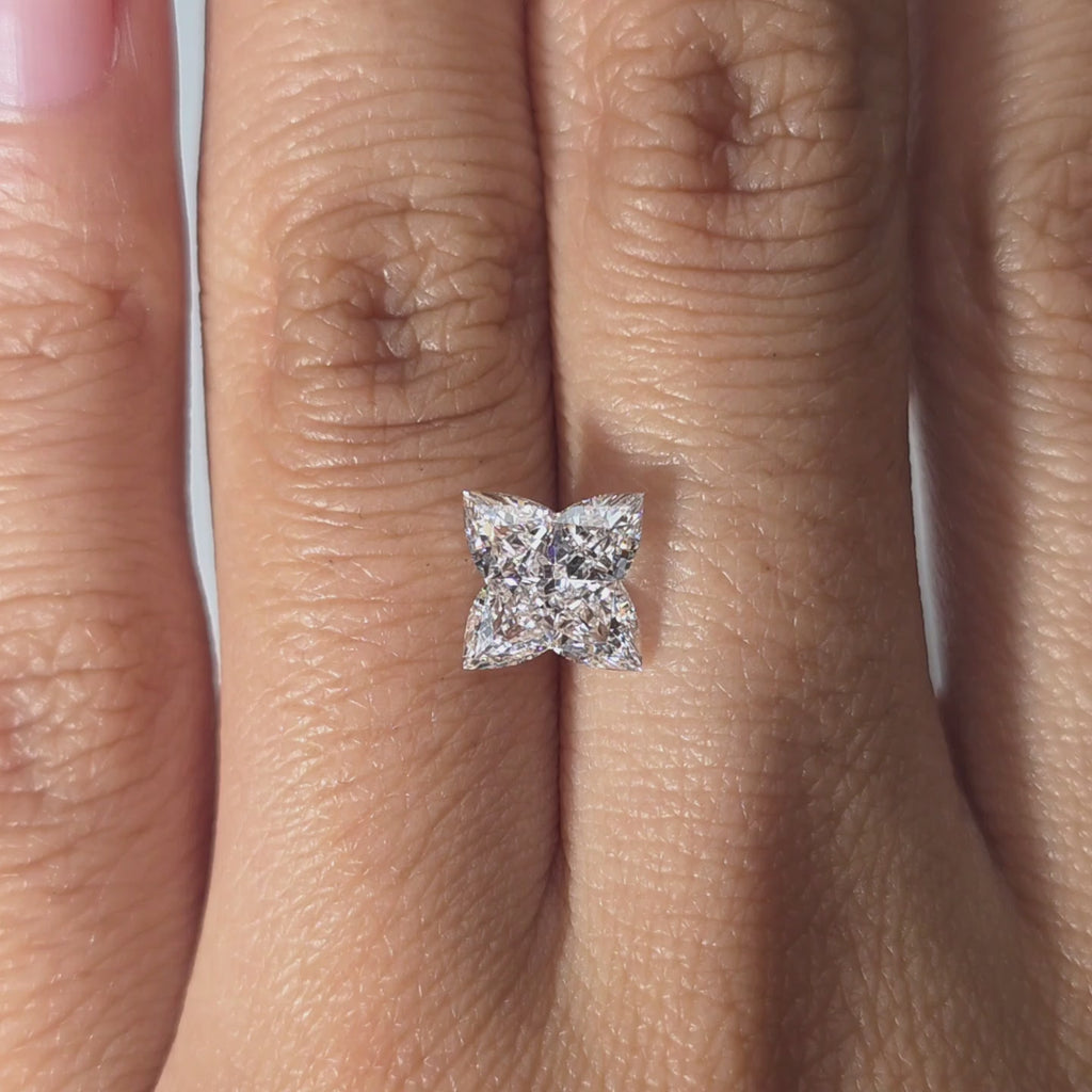 Custom lab diamond rings online: hand modeling a 2.20ct four leaf clover cut lab diamond indoors.