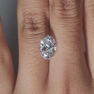 Close-up hand video of 2.45ct oval diamond in cozy indoor lighting
