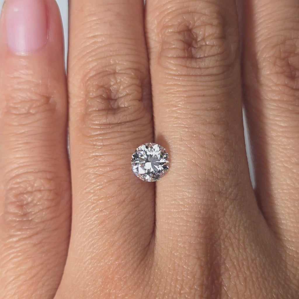 Hand showcasing a 1.07ct Crown Arrow Cut™ lab diamond in warm indoor setting.