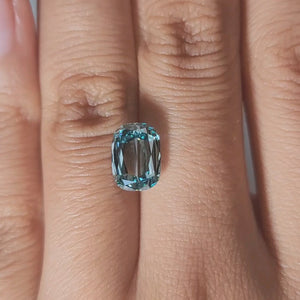 Close-up hand video of 3.002ct blue cushion diamond in warm lighting
