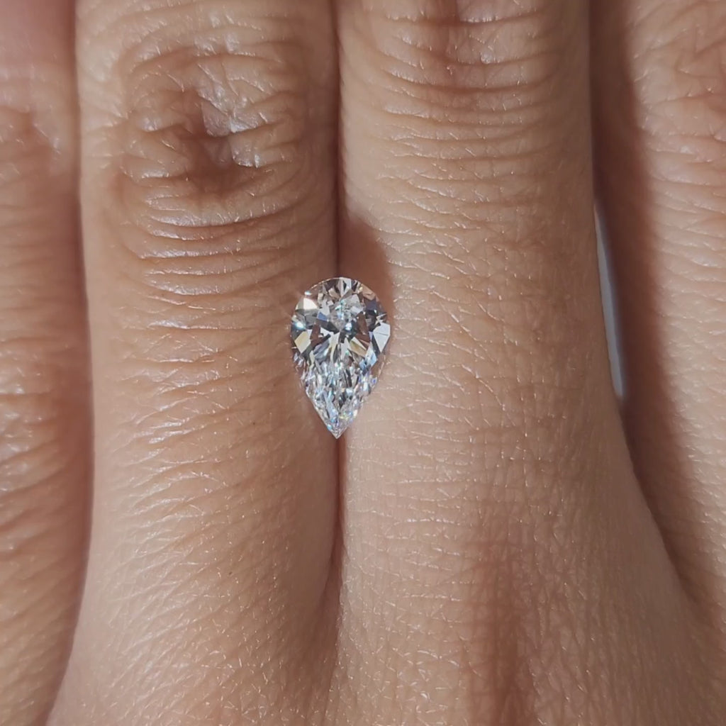 "Hand-modeled video of 1.01ct pear diamond in warm indoor lighting"