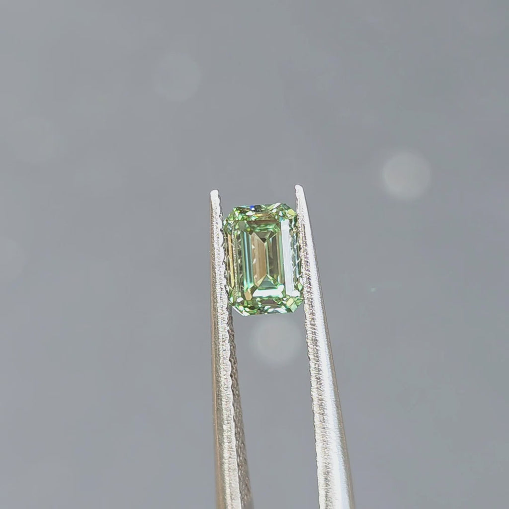 1.08ct emerald cut fancy vivid green VVS1 lab diamond displaying vibrant color in outdoor sunlight.