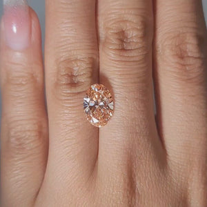 3.06ct Oval vivid pink diamond glowing in golden indoor light