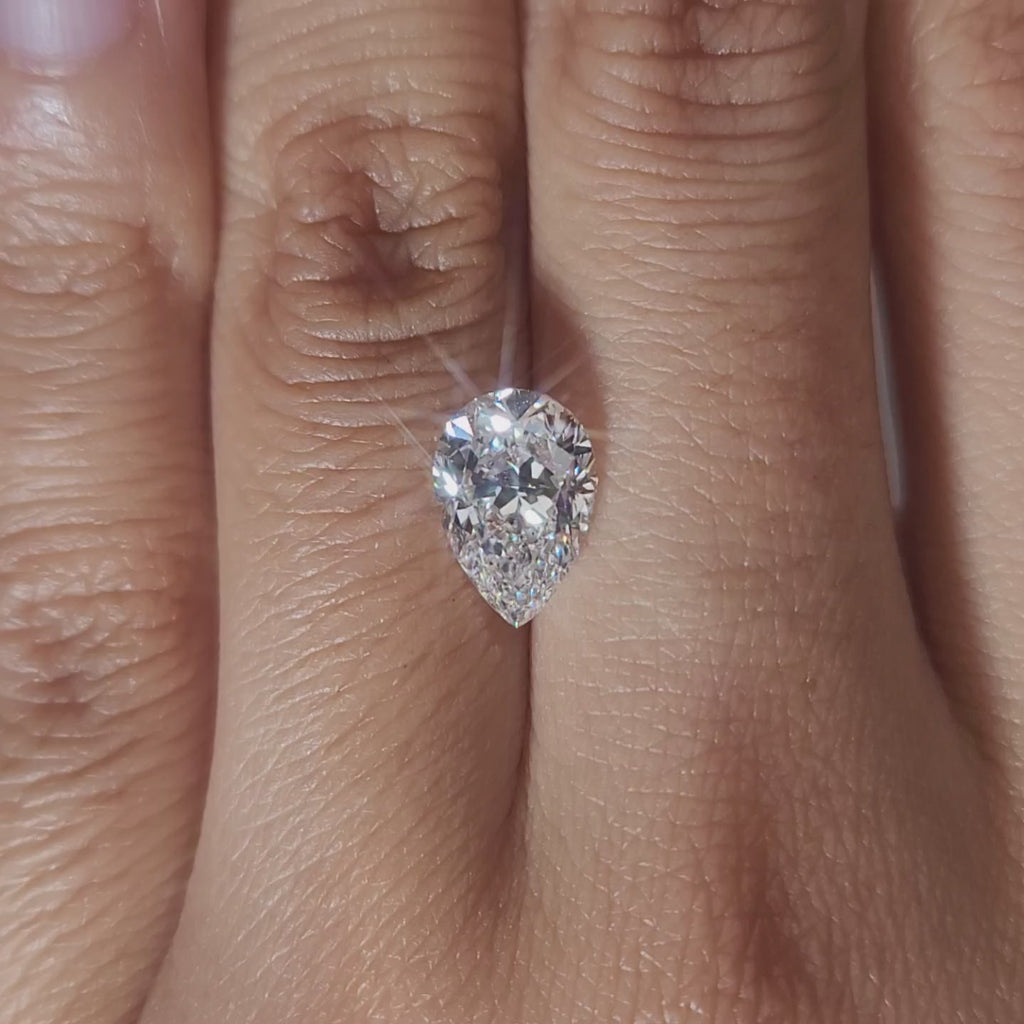 "Hand-modeled video of 2.037ct pear diamond in warm indoor lighting"
