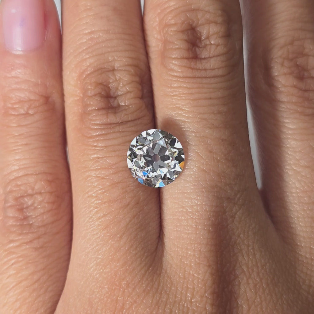 A 3.02ct round European cut lab diamond modeled in hand under warm indoor light.