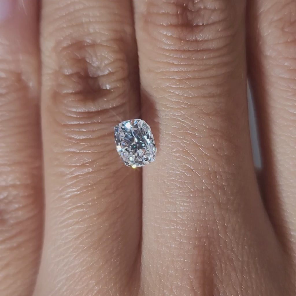 "Hand-modeled video of 1.03ct cushion diamond in warm indoor lighting"