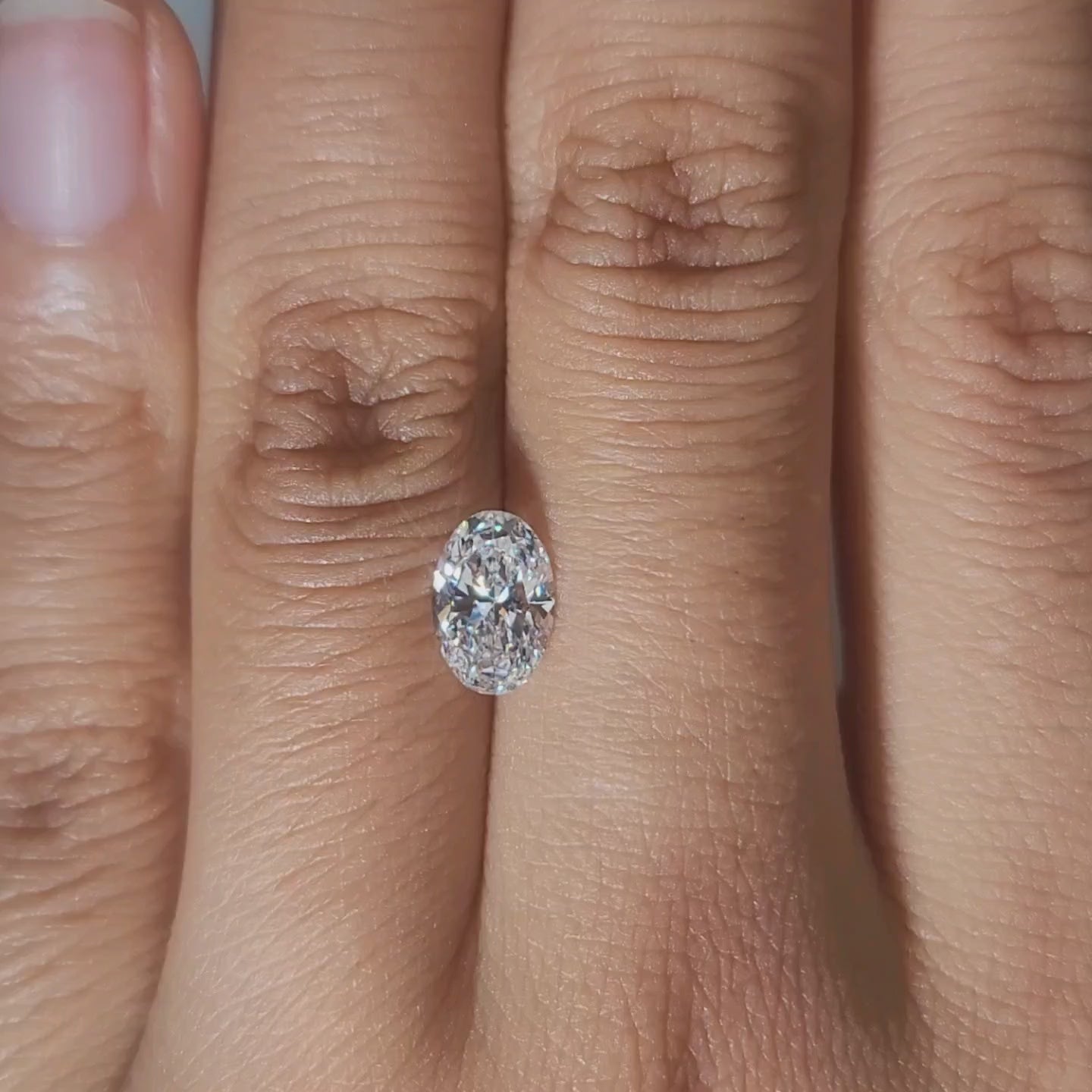 Close-up hand video of 1.03ct oval diamond in candlelight glow