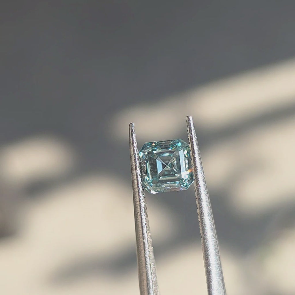 A 1.00ct asscher cut fancy vivid blue lab diamond viewed in outdoor sunlight.