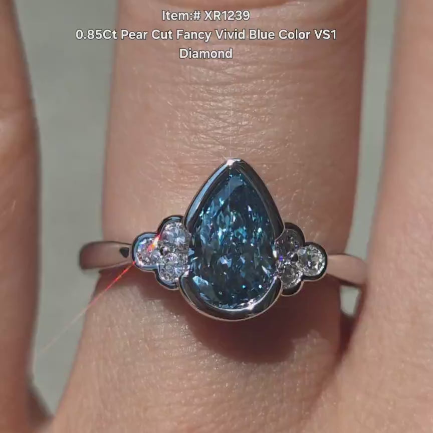 DovEggs fancy blue pear side stones lab diamond engagement ring in sunlight
