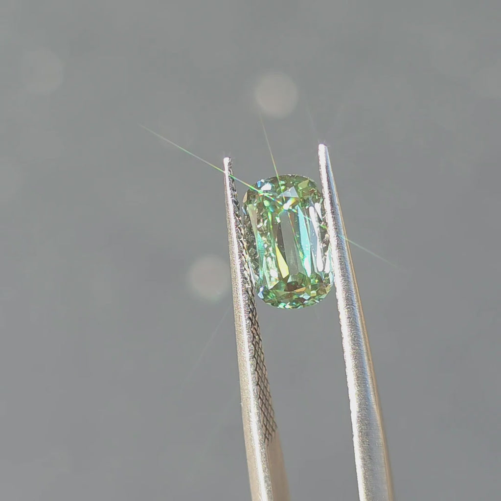 1.88ct cushion old mine cut fancy vivid green VVS1 lab diamond displaying vibrant color in outdoor sunlight.