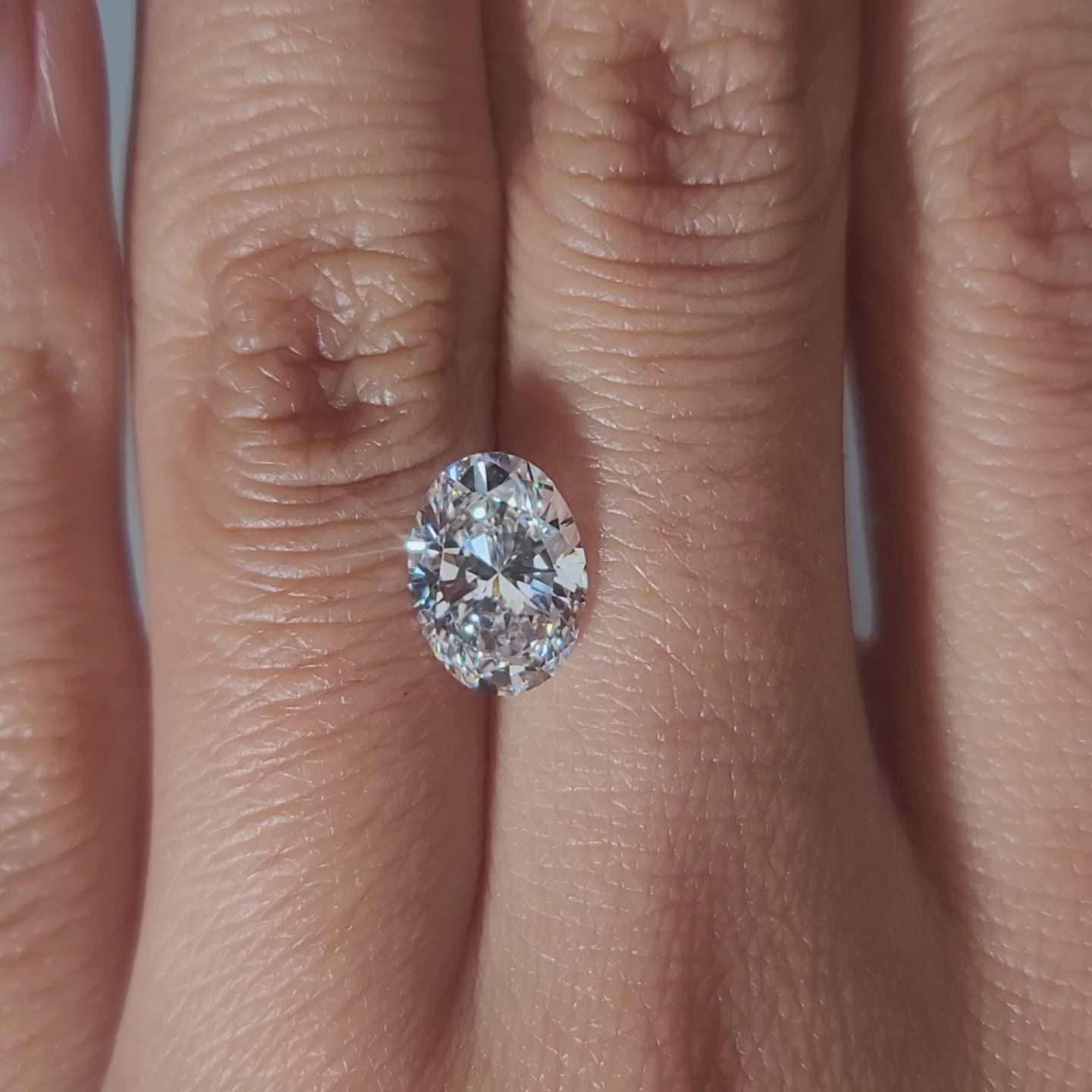 "Hand-modeled video of 2.009ct oval diamond in warm indoor lighting"