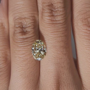 Hand-worn video of 2.005ct yellow oval diamond in warm interior lighting
