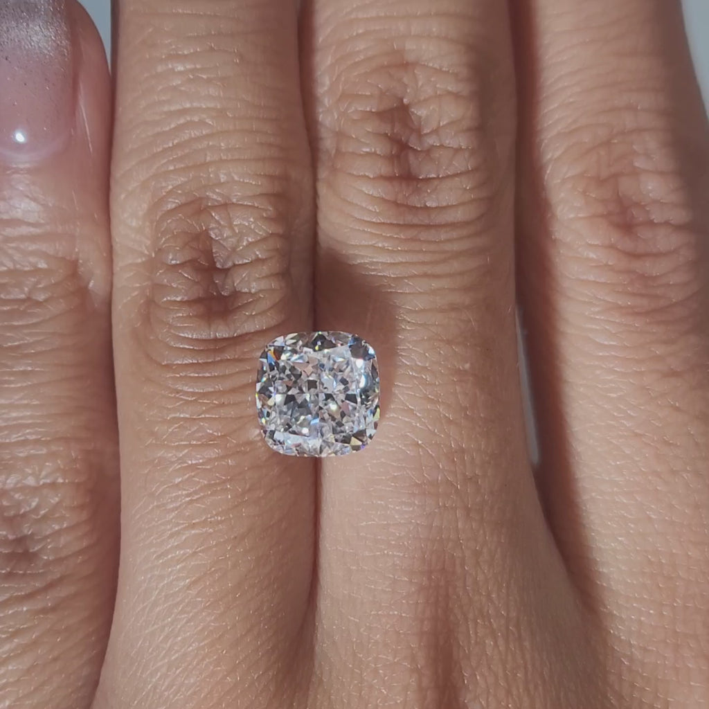 "Hand-modeled video of 3.485ct cushion diamond in warm indoor lighting"