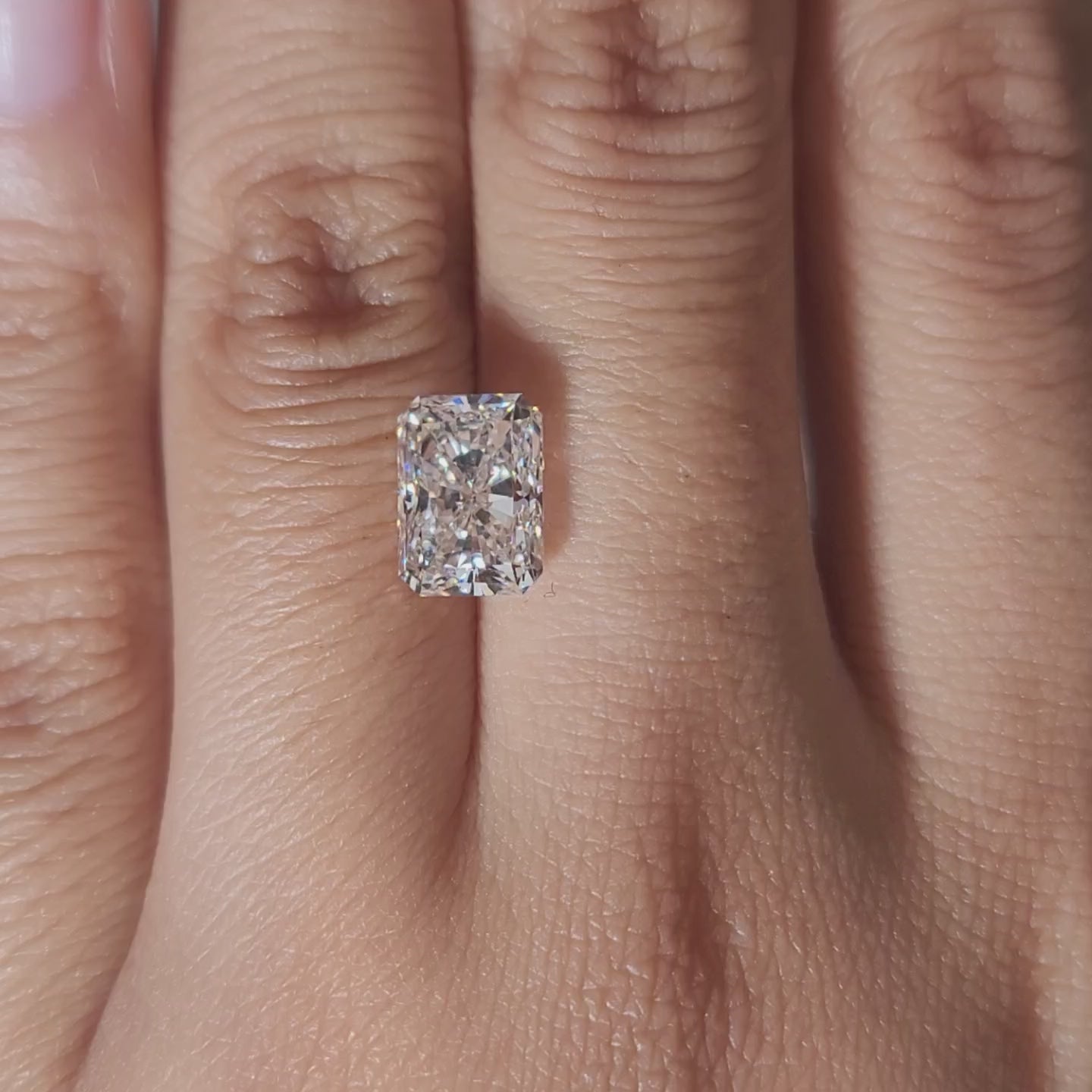 Close-up video of 3.07ct radiant cut diamond under warm indoor lighting, highlighting excellent cut and fire