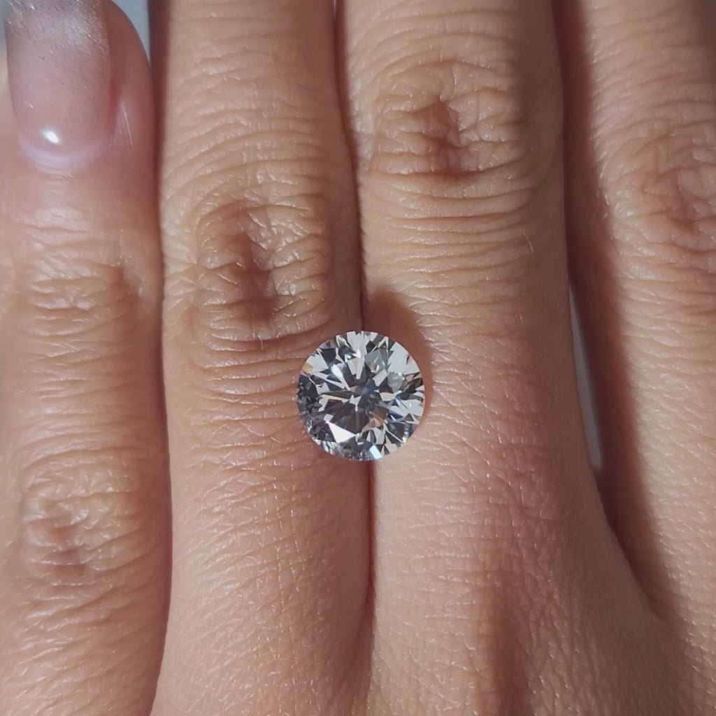"Hand-modeled video of 2.639ct round diamond in warm indoor lighting"