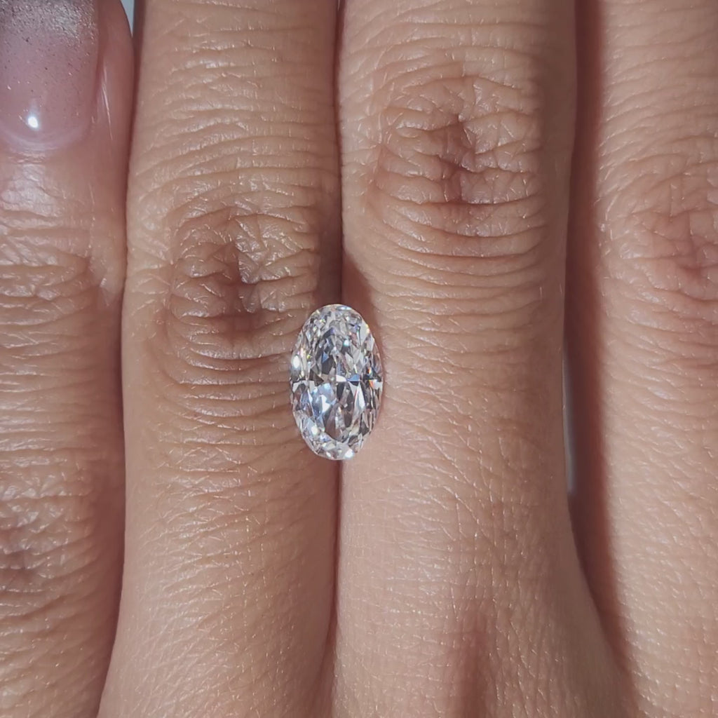 "Hand-modeled video of 1.590ct oval diamond in warm indoor lighting"