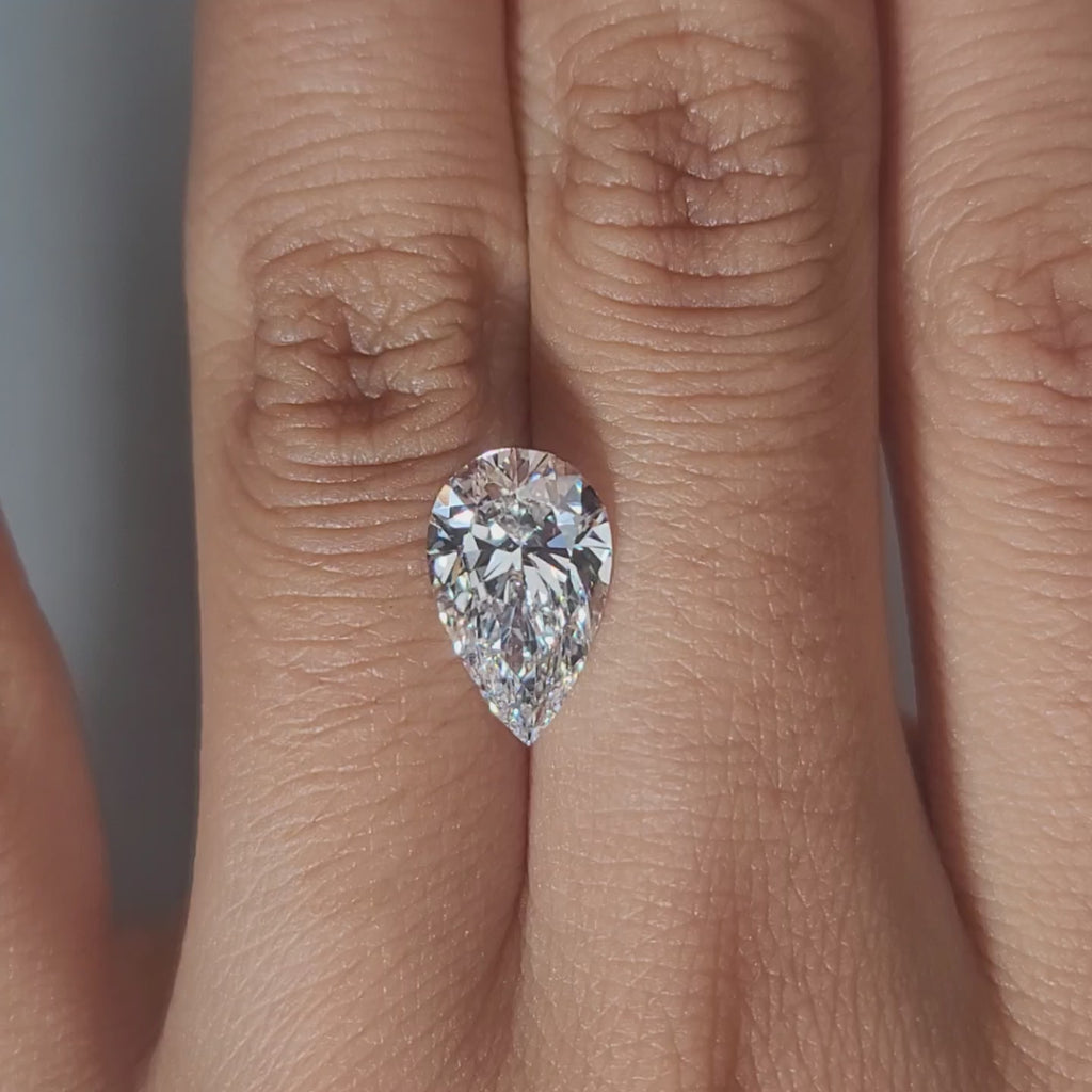 Close-up hand video of 2.75ct pear diamond in soft indoor lighting