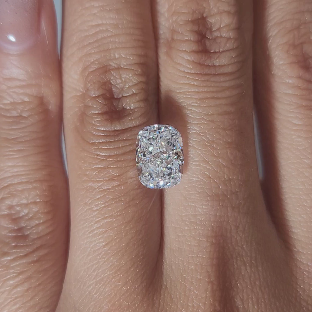 "Hand-modeled video of 2.751ct cushion diamond in warm indoor lighting"