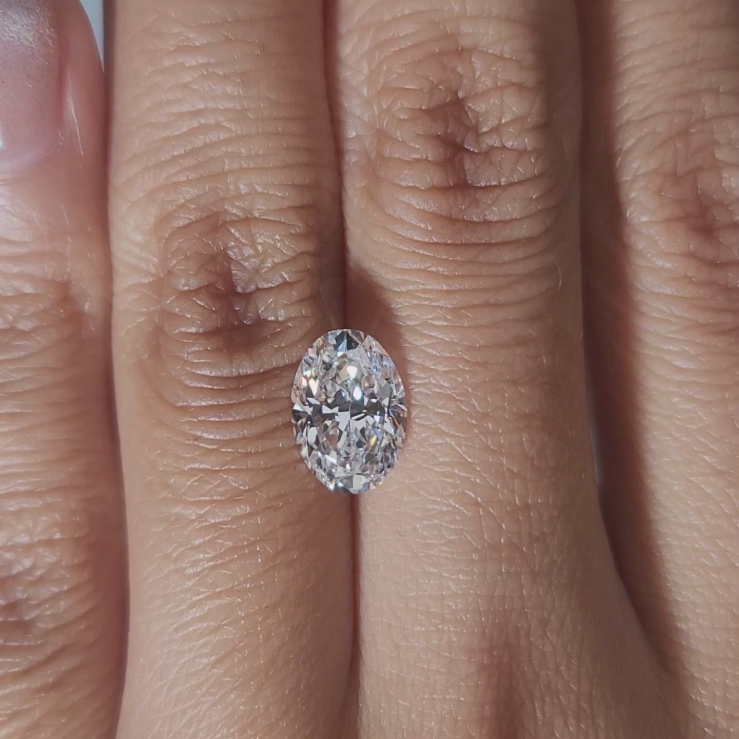 "Hand-modeled video of 2.011ct oval diamond in warm indoor lighting"