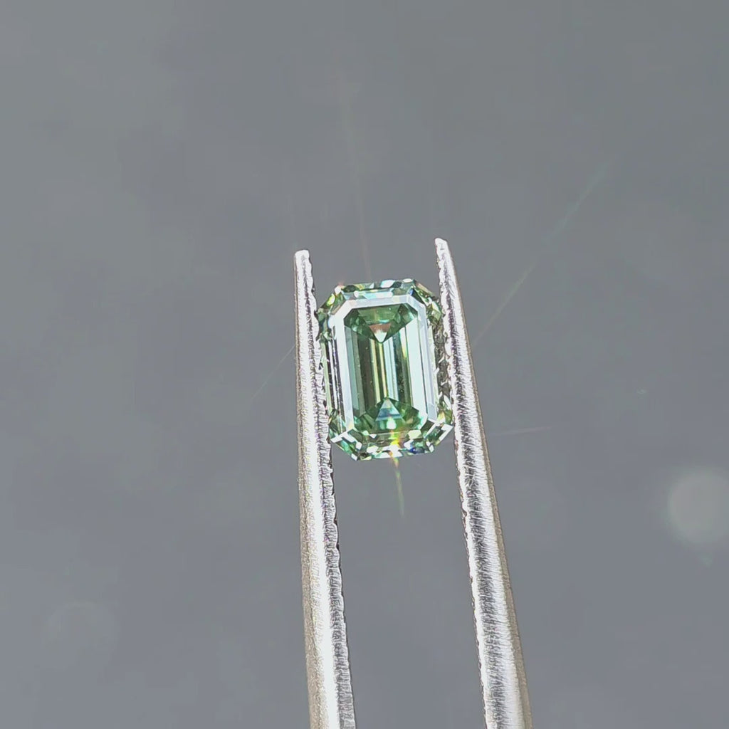 1.10ct emerald cut fancy vivid green VVS1 lab diamond displaying vibrant color in outdoor sunlight.