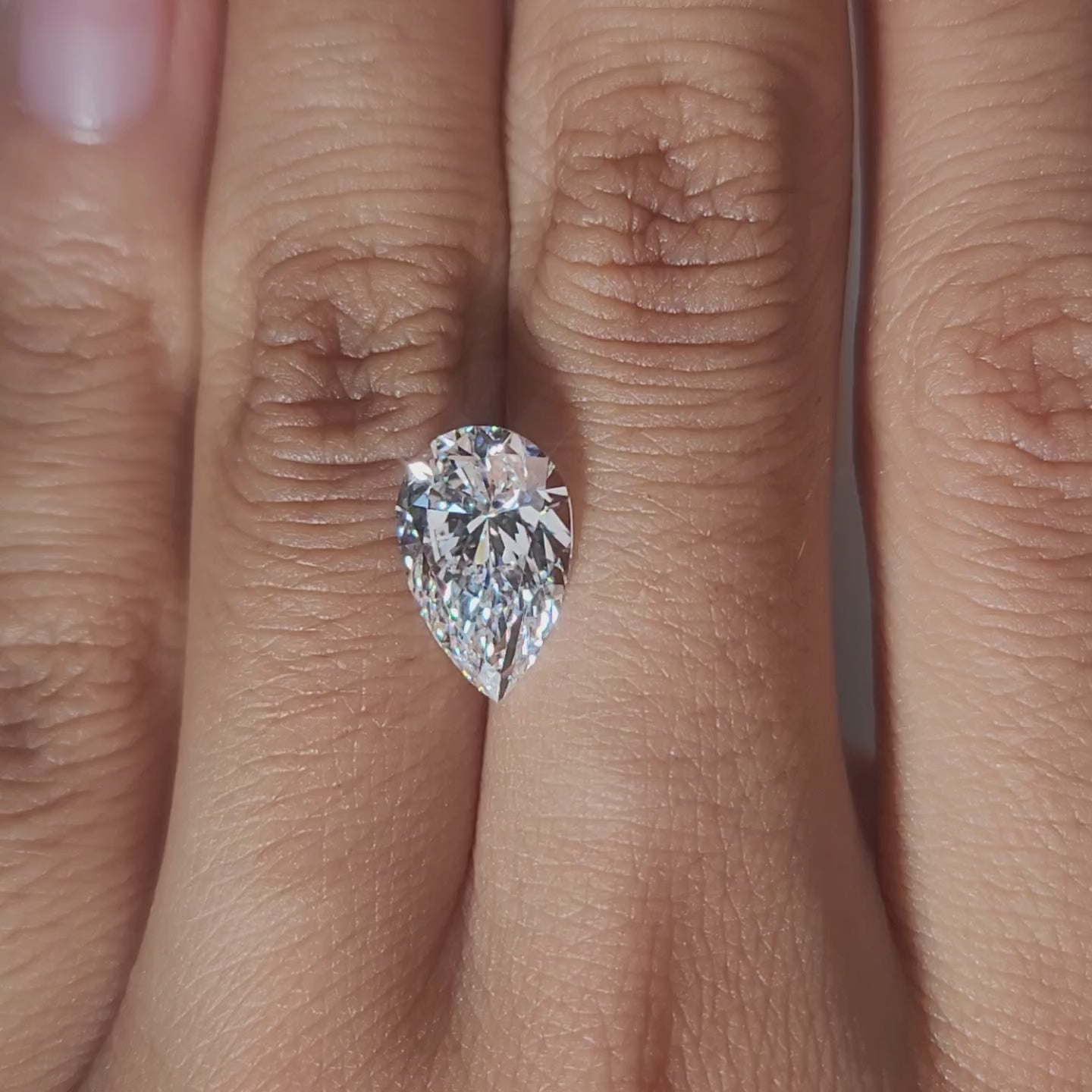 Finger-modeled video of 3.018ct pear diamond in ambient indoor light