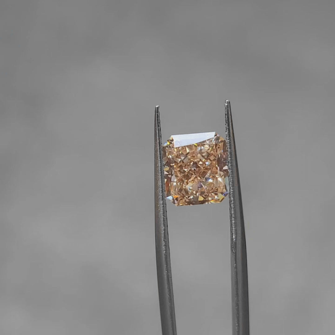 3.65ct radiant fancy vivid orange diamond outdoors, displaying fiery color