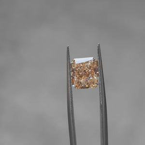 3.65ct radiant fancy vivid orange diamond outdoors, displaying fiery color