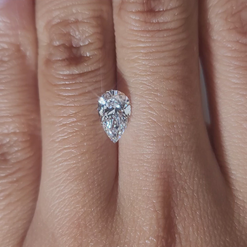 "Hand-modeled video of 1.19ct pear diamond in warm indoor lighting"