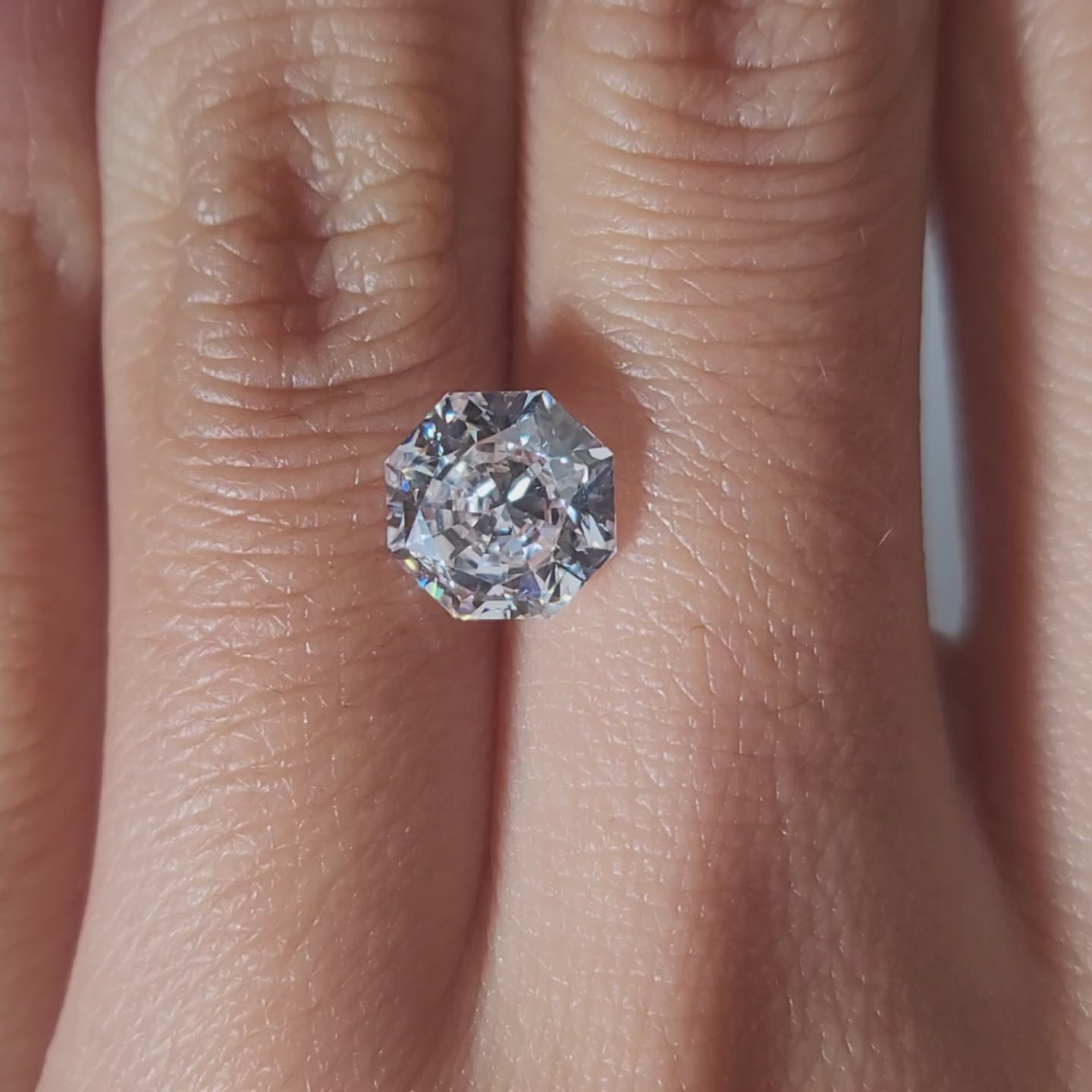 "Hand-modeled video of 2.165ct octagon diamond in warm indoor lighting"