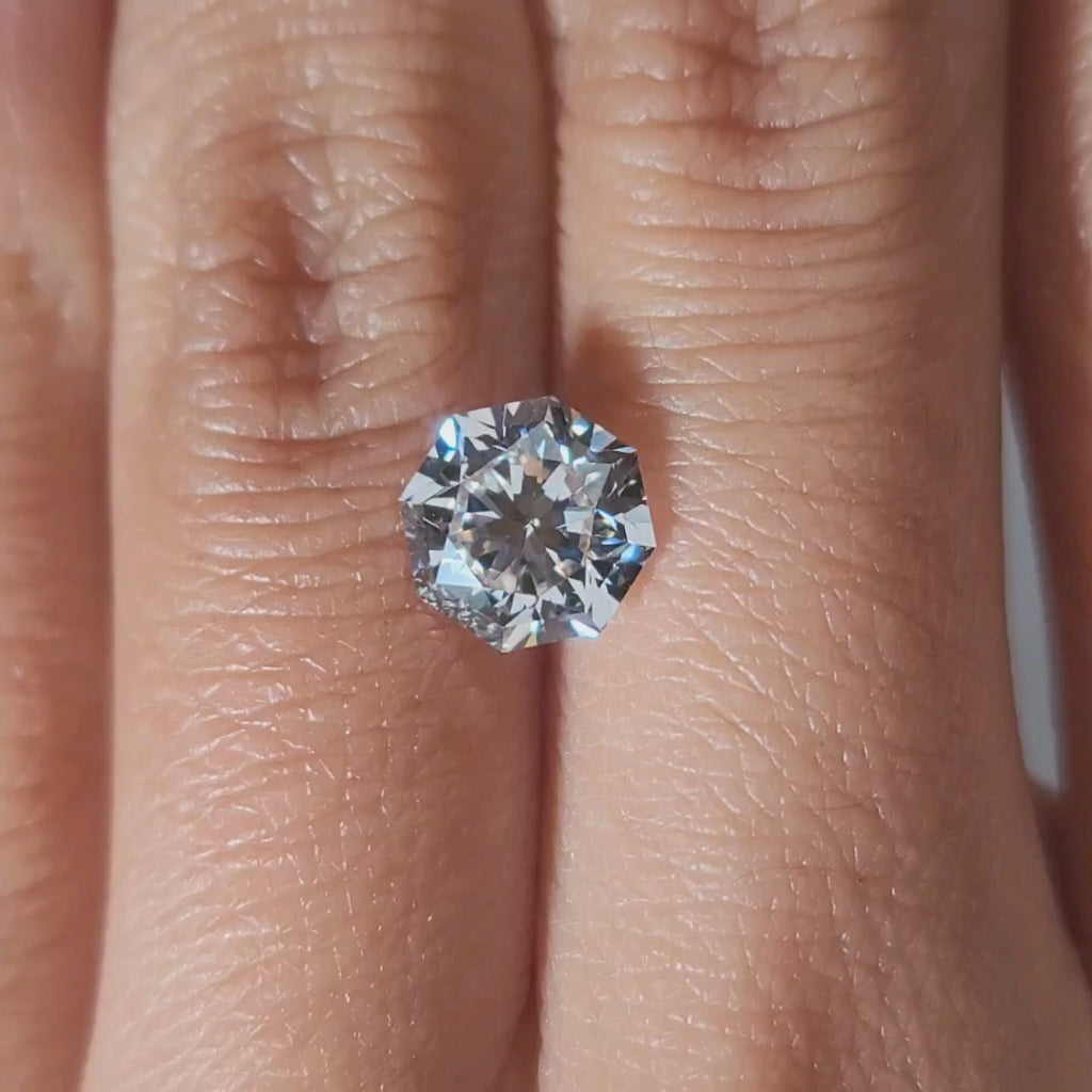 "Hand-modeled video of 2.111ct octagon diamond in warm indoor lighting"