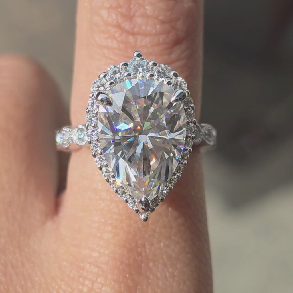 XR0339 ring with 7ct pear moissanite on hand under outdoor lighting
