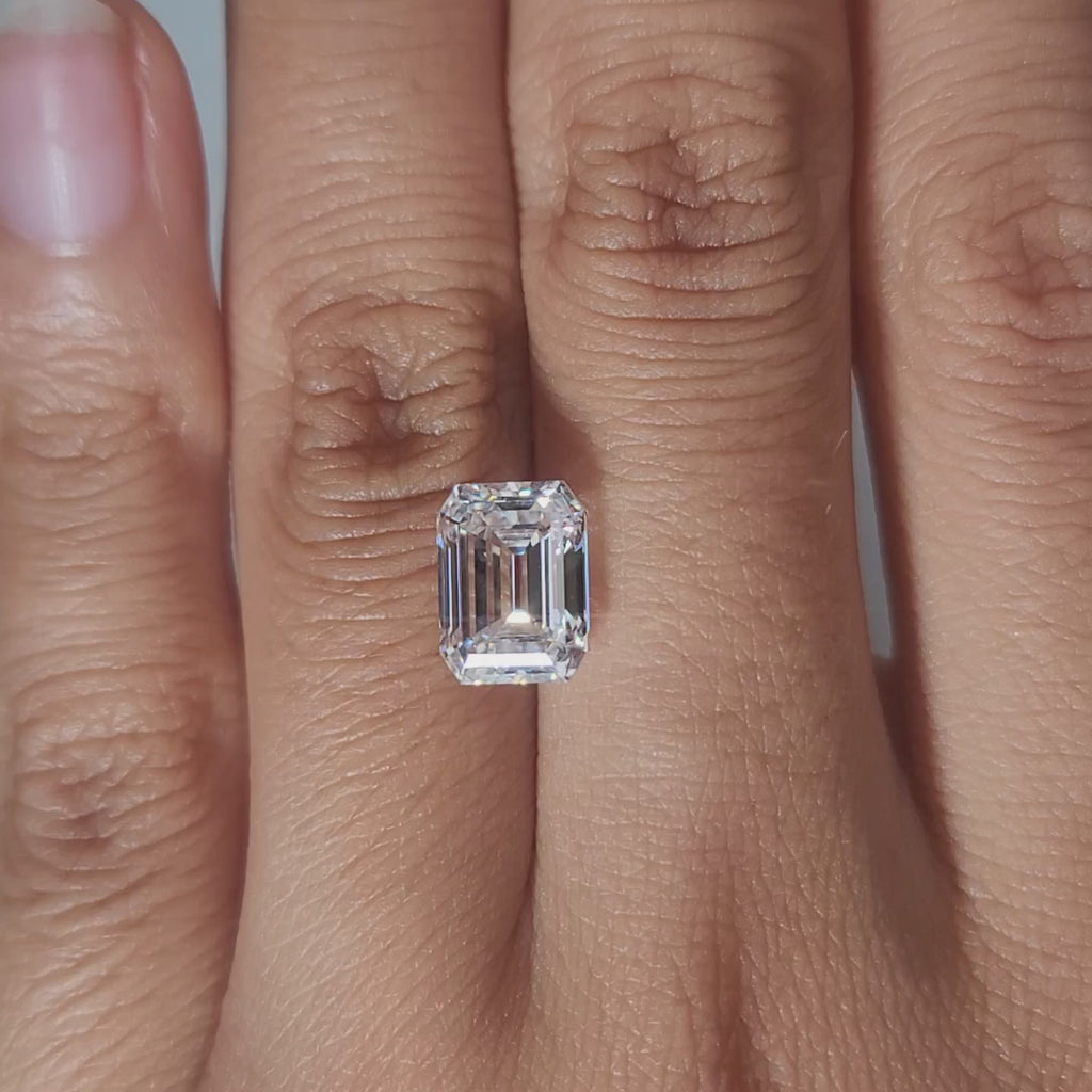 Hand-modeled video of 3.124ct emerald diamond in warm lighting highlighting VVS2 clarity