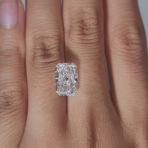 Close-up hand video displaying 4.303ct radiant diamond in cozy indoor light