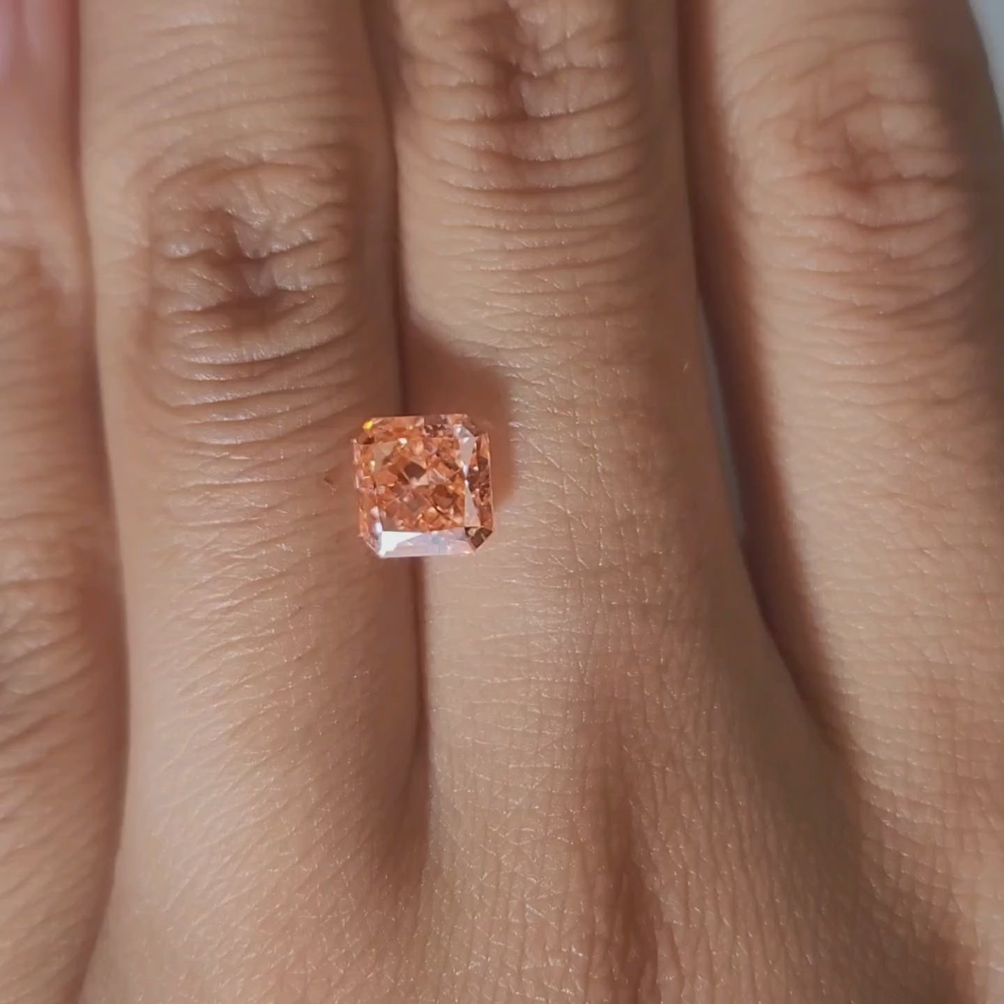 Hand-worn video of 1.535ct pink-orange diamond in warm indoor light