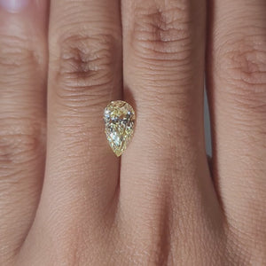 Hand-modeled video of 1.67ct vivid yellow pear diamond under warm light