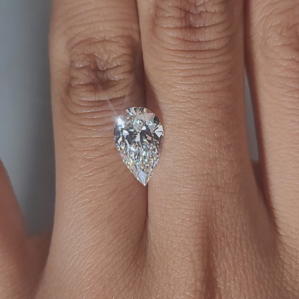 Finger-modeled video of 2.31ct pear diamond under warm indoor lights