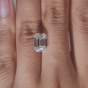 Close-up hand video of 3.303ct E-color emerald diamond in warm light
