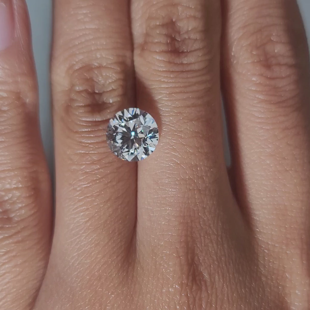 "Hand-modeled video of 3.055ct round diamond in warm indoor lighting"