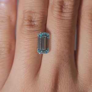 "Hand-worn video showcasing 3.03ct bluish green emerald cut in gallery lighting"