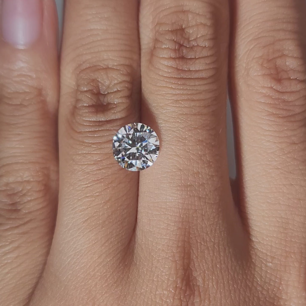 Hand-display video showing 2.050ct round diamond in warm home lighting