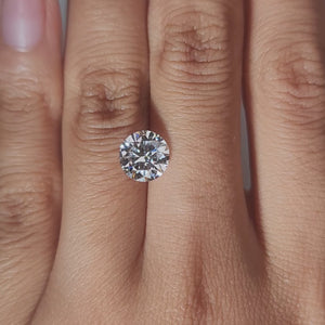 Hand-display video showing 2.050ct round diamond in warm home lighting